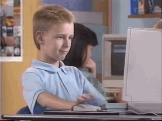Boy with mullet giving a thumbs up at computer